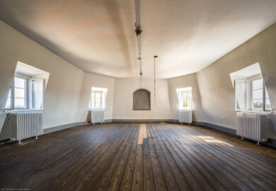 Waghäusel - Eremitage - Hauptbau - Von Innen - 2. Obergeschoss - Östlicher Flügelanbau - Blick in das Dachzimmer; hinter der Bretterabdeckung in der Mitte befindet sich die Uhr des Zentralbaus, 1783 nachträglich eingebaut; mit dem herabhängenden Seil kann man die Glocke des Glockentürmchens läuten (aufgenommen im September 2021, am Nachmittag)