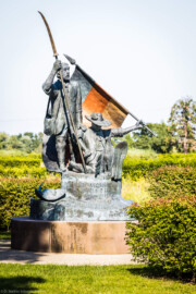 Waghäusel - Eremitage - Von Außen - Von Süden - Blick auf das Freiheitsdenkmal zum Gedenken an die Schlacht bei Waghäusel 1849 (Senkrechte Inschrift: "Den Wegbereitern der Demokratie - 21. Juni 1999"; schräge Inschrift: "In dankbarer Erinnerung an den Einsatz vieler Männer und Frauen für Freiheit und Menschenrechte in der Badischen Revolution von 1848-1849 wurde dieses Denkmal von der Stadt Waghäusel zum 150. Jahrestag der Schlacht von Waghäusel und des Gefechtes von Wiesental errichtet"; Inschrift in der Fahne: "Fond. Veneta d'Arte Verona Italia") (Skulptur aus Bronze, geschaffen 1999 von dem Speyerer Künstler Franz-Werner Müller-Steinfurt (1952-2017)) (aufgenommen im September 2021, am Nachmittag) Waghäusel - Eremitage - Von Außen - Von Süden - Blick auf das Freiheitsdenkmal zum Gedenken an die Schlacht bei Waghäusel 1849 (Senkrechte Inschrift: "Den Wegbereitern der Demokratie - 21. Juni 1999"; schräge Inschrift: "In dankbarer Erinnerung an den Einsatz vieler Männer und Frauen für Freiheit und Menschenrechte in der Badischen Revolution von 1848-1849 wurde dieses Denkmal von der Stadt Waghäusel zum 150. Jahrestag der Schlacht von Waghäusel und des Gefechtes von Wiesental errichtet"; Inschrift in der Fahne: "Fond. Veneta d'Arte Verona Italia") (Skulptur aus Bronze, geschaffen 1999 von dem Speyerer Künstler Franz-Werner Müller-Steinfurt (1952-2017)) (aufgenommen im September 2021, am Nachmittag)