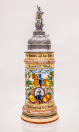 Städtisches Museum Bruchsal - Schloss Bruchsal - Hauptbau / Corps de Logis - Nördlicher Raum, Bereich Gelbe Dragoner - Reservistenkrug des ehemaligen Dragoners Bloch (Dienstzeit 1909-1912) (Bildnis unterhalb der Mitte: Friedrich II., Großherzog von Baden (reg. 1907-1918); Inschriften von oben nach unten: Deckel: Mitte "Reserve hat Ruh", links "Ihr Brüder stosst die Glässer an - es lebe der Reservemann", rechts "Der treu gedient hat seine Zeit - dem sei ein volles Glas geweiht"; Krug ganz oben, Mitte: "Stolz zu Roß die Cavallerie auf dem Posten spät und früh"; darunter: "Reservist Bloch"; darunter, Mitte: "So lang ich leben werde vergessen werd ichs nie - Ich bin ein Lanzenreiter der deutschen Cavallerie", darunter "Sieg oder Tod", darunter "Ob zu Fuß oder zu Pferd - Oder hinter der Kanone - Schützen wir der Heimat Herd - Und dem Fürsten seine Krone"; links: "Wenn Dragoner patroullieren - Und den stärksten Feind aufspüren - Aufklären tun sie das Gelände - Der Feind fällt ihnen in die Hände"; rechts: "Die Trompete ruft zum Scheiden - Drum mein Mädchen lebe wohl" und "Des Reservisten letzte Einquartierung" und "Behüt dich Gott, es wär so schön gewesen - Behüt dich Gott, es hat nicht sollen sein"; darunter links und rechts "Erinnerung an meine Dienstzeit"; darunter Mitte "3. Esk. 2. Bad. Drag. Regt. Nr 21. Bruchsal. 1909-12."; Rückseite: links: "Reservist Bloch Blumhofer Dinger Dinkel Gerstner Gräble Häfele Hoffmann Melin Jakobi Klump Kramb Lotz", rechts: "Reservist Mantel Renz Michils Schuster Schwarz Schreiber Steinmann Stiebing Stoffel Weigel Weis Ziegler"; Inv.Nr. 2008.1) (aufgenommen im September 2021, am frühen Nachmittag)