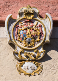 Schloss Bruchsal - Kirchturm - Von Außen / Von Osten - Blick auf das Landeswappen des Fürstbistums Speyer zur Regierungszeit des Fürstbischofs Kardinal Damian Hugo Philipp von Schönborn-Buchheim mit der Jahreszahl 1742 (links oben und links unten, rechte Hälfte: Wappen des Bistums Speyer, links unten, linke Hälfte: Wappen der Fürstpropstei Weissenburg, rechts: persönliches Wappen von Damian Hugo von Schönborn, Mitte/unten: zweifaches Deutsch-Ordenskreuz für die Ordensballeien Altenbiesen und Hessen) (aufgenommen im März 2022, um die Mittagszeit)