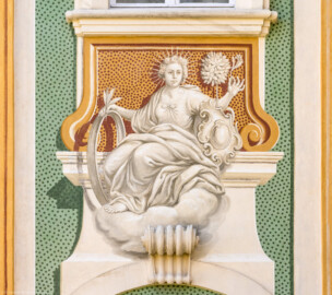 Schloss Bruchsal - Südliche Orangerie / Kavaliersbau - Von Außen - Von Westen - Blick auf die 11. (von Norden/von links gezählt) Allegorie bzw. Figur: vermutlich die "Botanik" (ursprünglich gemalt von Giovanni Francesco Marchini, zwischen 1732 und 1737, restauriert von Josef Mariano Kitschker, zwischen 1900 und 1910, erneut restauriert von Klaus Siller (Fassadenmalerei) und  Walter Maschke (Allegorien), 1976) (aufgenommen im März 2022, um die Mittagszeit)