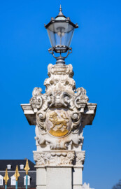 Schloss Bruchsal - Ehrenhof - Südliches Tor, westlicher Torpfosten, Südseite - Blick auf den Torpfosten mit Laterne und dem Familienwappen von Damian Hugo Philipp von Schönborn-Buchheim (aufgenommen im März 2022, am Nachmittag)