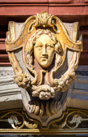 Schloss Bruchsal - Kammerflügel - Von Süden / Hofseite - Mittelrisalit - Südportal - Blick auf die Volute / Kartusche mit Kopf oberhalb der Tür / unterhalb des Balkons (aufgenommen im März 2022, am Nachmittag) Schloss Bruchsal - Kammerflügel - Von Süden / Hofseite - Mittelrisalit - Südportal - Blick auf die Volute / Kartusche mit Kopf oberhalb der Tür / unterhalb des Balkons (aufgenommen im März 2022, am Nachmittag)