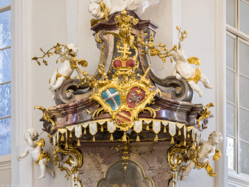 Bruchsal - Peterskirche / St. Peter - Von Innen - Von Südwesten - Kanzel - Blick auf den reichhaltig geschmückten Schalldeckel der Kanzel - In der Mitte das bischöfliche speyerische Hutten-Wappen (links oben: Wappen des Bistums Speyer, rechts oben: Wappen der Fürstpropstei Weissenburg, mitte unten: Familienwappen von Franz Christoph von Hutten zum Stolzenberg) (Kanzel geschaffen von Johann Michael Feuchtmayer, 1756; Altar erstellt 1996) (aufgenommen im März 2022, am Nachmittag, nach der Renovierung) Bruchsal - Peterskirche / St. Peter - Von Innen - Von Südwesten - Kanzel - Blick auf den reichhaltig geschmückten Schalldeckel der Kanzel - In der Mitte das bischöfliche speyerische Hutten-Wappen (links oben: Wappen des Bistums Speyer, rechts oben: Wappen der Fürstpropstei Weissenburg, mitte unten: Familienwappen von Franz Christoph von Hutten zum Stolzenberg) (Kanzel geschaffen von Johann Michael Feuchtmayer, 1756; Altar erstellt 1996) (aufgenommen im März 2022, am Nachmittag, nach der Renovierung)