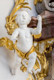 Bruchsal - Peterskirche / St. Peter - Von Innen / Von Nordwest - Blick auf einen Putto am Deckel der Kanzel (Kanzel geschaffen von Johann Michael Feuchtmayer, 1756) (aufgenommen im März 2022, am Nachmittag, nach der Renovierung)