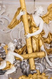 Bruchsal - Peterskirche / St. Peter - Hochaltar, Mitte, oberhalb des Altarbildes - Blick von der Orgelempore auf den Engel mit dem Petruskreuz und einen Putto (Altar entworfen von Balthasar Neumann und Johann Wolfgang van der Auwera, vor 1747) (aufgenommen im März 2022, am Nachmittag, nach der Renovierung)