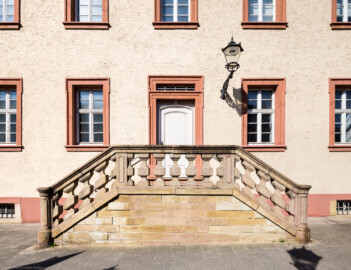Schloss Bruchsal - Landhospital / Seminarbau - Östlicher Mitteltrakt, Ostseite, nördlicher Eingang - Von Außen - Von Osten - Blick auf einen Teil der Ostfassade mit der nördlichen Außentreppe (aufgenommen im März 2022, am späten Vormittag)