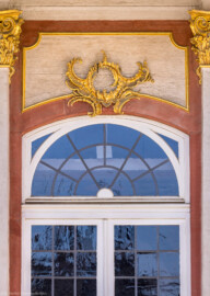 Schloss Bruchsal - Von Außen - Hauptbau / Corps de Logis - Von Osten / Hofseite - Mittelrisalit / Eingang - Blick auf einen Bereich des oberen rechten / nördlichen Fensters mit den Stuckverzierungen (aufgenommen im März 2022, am frühen Nachmittag) Schloss Bruchsal - Von Außen - Hauptbau / Corps de Logis - Von Osten / Hofseite - Mittelrisalit / Eingang - Blick auf einen Bereich des oberen rechten / nördlichen Fensters mit den Stuckverzierungen (aufgenommen im März 2022, am frühen Nachmittag)