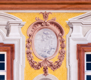 Schloss Bruchsal - Kirchenflügel / Hofkirche / St. Damian und Hugo - Von Westen - Blick vom Kavaliersbau auf die obere rechte Landschaftgrisaille sowie die illusionistischen Fassadenmalerei der Westfassade der Hofkirche (ursprünglich gemalt von Giovanni Francesco Marchini, zwischen 1732 und 1737) (aufgenommen im März 2022, am Nachmittag)