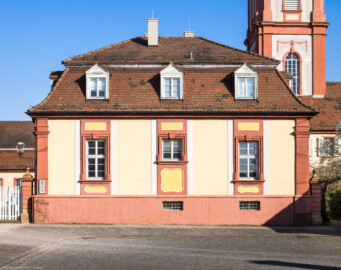 Schloss Bruchsal - Hofapotheke - Von außen - Von Westen - Blick vom Kavaliersbau nach Osten auf die Hofapotheke, links der Verbindungsbau, dahinter der Kirchturm (aufgenommen im März 2022, am späten Nachmittag)
