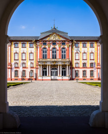 Schloss Bruchsal - Hauptbau / Corps de Logis - Von Außen - Von Osten / Hofseite - Blick vom Durchgang des Torwachtgebäudes auf die Ostfassade des Hauptbaus (aufgenommen im April 2022, am frühen Nachmittag) Schloss Bruchsal - Hauptbau / Corps de Logis - Von Außen - Von Osten / Hofseite - Blick vom Durchgang des Torwachtgebäudes auf die Ostfassade des Hauptbaus (aufgenommen im April 2022, am frühen Nachmittag)