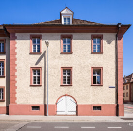 Schloss Bruchsal - Landhospital, Südlicher Trakt - Von Außen - Von Süden - Blick auf den ostlichen Teil der Südfassade entlang der Wilderichstraße, rechts im Hintergrund der Große Dienerbau (aufgenommen im April 2022, um die Mittagszeit)