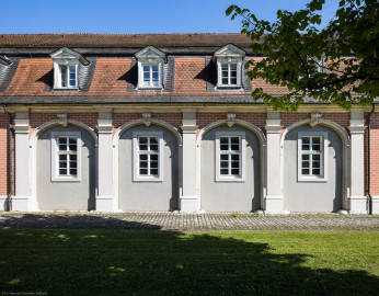 Schloss Bruchsal - Von Außen - Von Westen - Nördlicher Remisenbau - Blick von der Schönbornstraße auf den mittleren Teil der Westfassade der nördlichen Remise (aufgenommen im April 2022, am Nachmittag) Schloss Bruchsal - Von Außen - Von Westen - Nördlicher Remisenbau - Blick von der Schönbornstraße auf den mittleren Teil der Westfassade der nördlichen Remise (aufgenommen im April 2022, am Nachmittag)