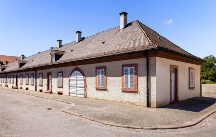 Schloss Bruchsal - Bandhof, westliche Häuserzeile - Von außen - Von Nordosten - Blick auf die Nordfassade (rechts) sowie einen Ausschnitt der Ostfassade (links) des westlichen Bandhofs (aufgenommen im Juli 2022, am frühen Nachmittag)
