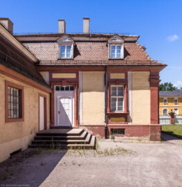 Schloss Bruchsal - Hofapotheke - Von außen - Von Osten - Blick auf die Ostfassade mit dem Eingang zur Hofapotheke, links die Hofsattlerei, rechts im Hintergrund die Südliche Orangerie (aufgenommen im Juli 2022, am frühen Nachmittag) Schloss Bruchsal - Hofapotheke - Von außen - Von Osten - Blick auf die Ostfassade mit dem Eingang zur Hofapotheke, links die Hofsattlerei, rechts im Hintergrund die Südliche Orangerie (aufgenommen im Juli 2022, am frühen Nachmittag)