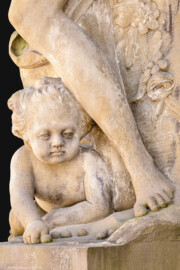 Schloss Bruchsal - Garten - Hauptachse, Südseite, 1. Skulptur von Osten - Kind (unten) der Skulptur "Der Frühling" aus dem Skulpturenensemble "Vier Jahreszeiten" (Kopie; Original gehauen 1759 von Joachim Günther, befindet sich im Harvard Art Museum / Fogg Museum) (aufgenommen im Juli 2022, am Nachmittag)