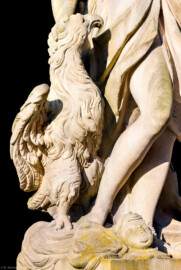 Schloss Bruchsal - Schlossgarten - Hauptachse, Südseite, 3. Skulptur von Osten - Adler (links unten) der Skulptur "Die Luft" aus dem Skulpturenensemble "Vier Elemente" (Kopie von Hans Volker Dursy; Original gehauen 1761 von Joachim Günther, befindet sich im Gartensaal des Hauptbaus) (aufgenommen im Juli 2022, am Vormittag)