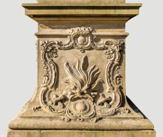 Schloss Bruchsal - Garten - Hauptachse, Südseite, 2. Skulptur von Osten - Nordseite / Frontseite des Sockels der Skulptur "Der Winter" aus dem Skulpturenensemble "Vier Jahreszeiten" (Kopie; Original gehauen 1759 von Joachim Günther, befindet sich im Harvard Art Museum / Fogg Museum) (aufgenommen im Juli 2022, am Vormittag)