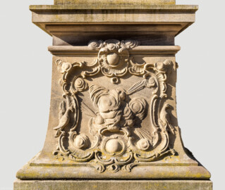 Schloss Bruchsal - Schlossgarten - Hauptachse, Südseite, 3. Skulptur von Osten - Nordseite / Frontseite des Sockels der Skulptur "Die Luft" aus dem Skulpturenensemble "Vier Elemente" (Kopie; Original gehauen 1761 von Joachim Günther, befindet sich im Gartensaal des Hauptbaus) (aufgenommen im Juli 2022, am Vormittag)