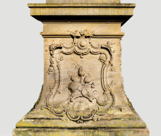 Schloss Bruchsal - Schlossgarten - Hauptachse, Südseite, 4. Skulptur von Osten - Ostseite / Linke Seite des Sockels der Skulptur "Die Erde" aus dem Skulpturenensemble "Vier Elemente" (Kopie; Original gehauen 1761 von Joachim Günther, befindet sich im Gartensaal des Hauptbaus) (aufgenommen im Juli 2022, am Vormittag)