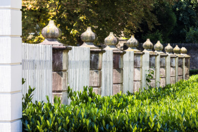 Schloss Bruchsal - Garten - Westeingang / Haltestelle Schlossgarten - Gartenzaun, südlich des südwestlichen Hauses  - Von Nordwest - Blick auf einen Gartenzaun mit Steinpfosten (aufgenommen im Juli 2022, am späten Vormittag)