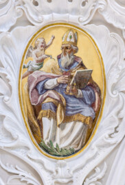 Bruchsal - Peterskirche / St. Peter - Vierungsgewölbe, Pendentif, unterhalb der Kuppel, Südostecke - Blick auf das Bildnis von Augustinus von Hippo (354-430, Kirchenlehrer, Kirchenvater) (gemalt von Josef Mariano Kitschker, zwischen 1907 und 1909) (aufgenommen im August 2022, um die Mittagszeit, nach der Renovierung)