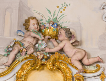 Schloss Bruchsal - Hauptbau / Corps de Logis - Beletage - Marmorsaal / Kaisersaal - Nordostecke, oben, Stuckfeld - Von Südwesten - Blick auf zwei Putti als allegorische Darstellung des Frühlings (Stuckaturen ursprünglich von Johann Michael Feichtmayr) (aufgenommen im August 2022, um die Mittagszeit) Schloss Bruchsal - Hauptbau / Corps de Logis - Beletage - Marmorsaal / Kaisersaal - Nordostecke, oben, Stuckfeld - Von Südwesten - Blick auf zwei Putti als allegorische Darstellung des Frühlings (Stuckaturen ursprünglich von Johann Michael Feichtmayr) (aufgenommen im August 2022, um die Mittagszeit)