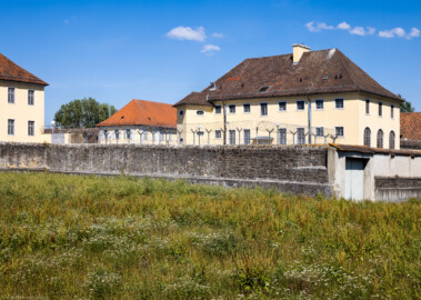 Bad Schönborn / Bad Mingolsheim - Schloss Kislau - Hauptbau / Kavalierbau / Küchenbau - Von Südosten - Blick vom Landgraben auf den Hauptbau (links), den Kavalierbau (Mitte), den Küchenbau (rechts) sowie auf die Umgebungsmauer (aufgenommen im August 2022, um die Mittagszeit)