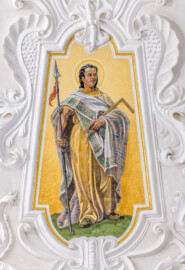 Bruchsal - Peterskirche / St. Peter - Kuppel, Apostelfiguren - Blick auf das Bildnis des Apostels Thomas; dargestellt mit einem Winkelmaß (Thomas als Architekt) und einer Lanze (Thomas soll mit einer Lanze ermordet worden sein) (gemalt von Josef Mariano Kitschker, zwischen 1907 und 1909) (aufgenommen im August 2022, am Nachmittag, nach der Renovierung)
