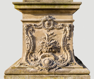 Schloss Bruchsal - Garten - Hauptachse, Südseite, 1. Skulptur von Osten - Nordseite / Frontseite des Sockels der Skulptur "Der Frühling " aus dem Skulpturenensemble "Vier Jahreszeiten" (Kopie; Original gehauen 1759 von Joachim Günther, befindet sich im Harvard Art Museum / Fogg Museum) (aufgenommen im August 2022, am Vormittag)