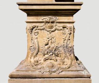 Schloss Bruchsal - Garten - Hauptachse, Nordseite, 2. Skulptur von Osten - Ostseite / rechte Seite des Sockels der Skulptur "Der Herbst" aus dem Skulpturenensemble "Vier Jahreszeiten" (Kopie; Original gehauen 1759 von Joachim Günther, befindet sich im Harvard Art Museum / Fogg Museum) (aufgenommen im August 2022, am späten Vormittag)