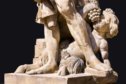Schloss Bruchsal - Garten - Hauptachse, Nordseite, 2. Skulptur von Osten - Satyrartige Figur (unten Mitte) der Skulptur "Der Herbst" aus dem Skulpturenensemble "Vier Jahreszeiten" (Kopie; Original gehauen 1759 von Joachim Günther, befindet sich im Harvard Art Museum / Fogg Museum) (aufgenommen im August 2022, am Nachmittag)