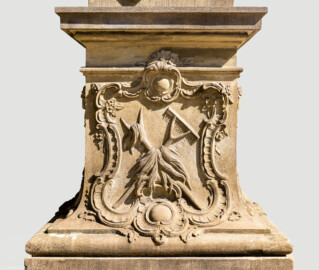 Schloss Bruchsal - Garten - Hauptachse, Nordseite, 1. Skulptur von Osten - Westseite / linke Seite des Sockels der Skulptur "Der Sommer" aus dem Skulpturenensemble "Vier Jahreszeiten" (Kopie; Original gehauen 1759 von Joachim Günther, befindet sich im Harvard Art Museum / Fogg Museum) (aufgenommen im August 2022, am Nachmittag)