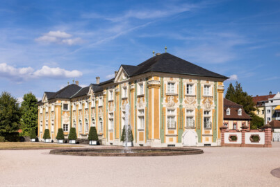 Schloss Bruchsal - Nördliche Orangerie / Nebendienstdienerbau - Von Südwest - Blick von der Schlossterrasse auf die Südwestfassade der nördlichen Orangerie, rechts dahinter die Mundkochwohnung  (aufgenommen im August 2022, am späten Nachmittag)