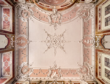 Bad Schönborn / Bad Mingolsheim - Schloss Kislau - Hauptbau - Von Innen - Badezimmer, Decke - Zentraler Blick nach oben auf die Decke des Badezimmers; links ist Osten, oben ist Norden; Stuckverzierungen erstellt vor 1770, Medaillons nach 1770 von Joachim Günther (1720-1789); Raum unter Franz Christoph von Hutten zum Stolzenberg zwischen 1761 und 1770 ausgebaut, später leicht verändert (aufgenommen im September 2022, am frühen Nachmittag)