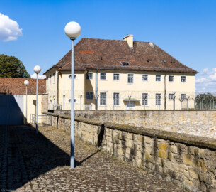 Bad Schönborn / Bad Mingolsheim - Schloss Kislau - Küchenbau  - Von Südwest - Blick von der Terrasse unterhalb des Erdgeschosses des Hauptbaus nach Nordosten auf den Küchenbau; im Vorder- und Hintergrund Teile der originalen Umgebungsmauern (aufgenommen im September 2022, am Nachmittag)