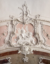 Bad Schönborn / Bad Mingolsheim - Schloss Kislau - Hauptbau - Von Innen - Badezimmer - Decke, Nordseite, Mitte - Von unten - Blick von unten auf eine Kartusche an der Decke mit zwei badenden Kindern, darunter eine Kopfkartusche; Stuckkartuschen erstellt vor 1770 von Joachim Günther (1720-1789) (aufgenommen im September 2022, am frühen Nachmittag)