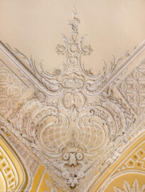 Schloss Bruchsal - Kammerflügel - Von innen - Kammermusiksaal - Decke, südwestliche Ecke - Blick von unten senkrecht nach oben auf Stuckdekorationen (Saal ursprünglich gestaltet von Joachim Günther; heute genutzt von den Bruchsaler Schlosskonzerten) (aufgenommen im Februar 2023, am späten Vormittag)