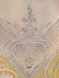 Schloss Bruchsal - Kammerflügel - Von innen - Kammermusiksaal - Decke, nordwestliche Ecke - Blick von unten senkrecht nach oben auf Stuckdekorationen (Saal ursprünglich gestaltet von Joachim Günther; heute genutzt von den Bruchsaler Schlosskonzerten) (aufgenommen im Februar 2023, am späten Vormittag)