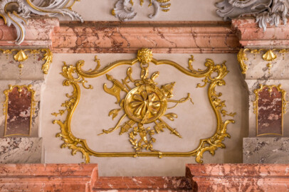 Schloss Bruchsal - Hauptbau / Corps de Logis - Von innen - Beletage - Marmorsaal / Kaisersaal - Südwand, östliche Hälfte, zwischen oberen Gesimsen - Von Norden - Blick auf ein Feld mit vergoldeten Stuckverzierungen (aufgenommen im März 2023, am Nachmittag)