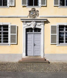 Bad Schönborn / Bad Mingolsheim - Schloss Kislau - Kavalierbau, Mitte - Von Osten - Blick auf die zentrale Tür mit dem Allianzwappen und dem Monogram ("FC") von Franz Christoph von Hutten zum Stolzenberg (aufgenommen im April 2023, am späten Vormittag)