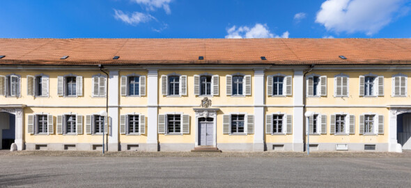 Bad Schönborn / Bad Mingolsheim - Schloss Kislau - Kavalierbau - Von Osten - Blick vom zentralen Brunnen nach Westen auf den Mittelteil des Kavalierbaus (aufgenommen im April 2023, um die Mittagszeit)