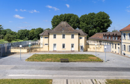 Bad Schönborn / Bad Mingolsheim - Schloss Kislau - Krankenbau / Stallungsgebäude /  Kavalierbau - Von Osten - Blick vom mittleren Fenster des 1. Obergeschosses des Küchenbaus nach Westen auf den ehemaligen Ehrenhof, den Krankenbau (ehemals Heiduckenbau bzw. Lakaienspeisehaus, in der Mitte),  ein ehemaliges Stallungsgebäude (rechts der Mitte, nach hinten) sowie den Kavalierbau (ganz rechts) (ganz rechts) (aufgenommen im Juni 2023, am späten Vormittag)