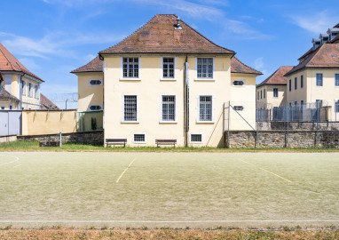 Bad Schönborn / Bad Mingolsheim - Schloss Kislau - Krankenbau / Kavalierbau / Hauptbau - Von Westen - Blick vom ehemaligen Garten (heute Sportplatz) auf die Westfassade des Krankenbaus (ehemals Heiduckenbau bzw. Lakaienspeisehaus, in der Mitte), links der Kavalierbau, rechts die beiden Flügel des Hauptbaus (aufgenommen im Juni 2023, am Nachmittag) Bad Schönborn / Bad Mingolsheim - Schloss Kislau - Krankenbau / Kavalierbau / Hauptbau - Von Westen - Blick vom ehemaligen Garten (heute Sportplatz) auf die Westfassade des Krankenbaus (ehemals Heiduckenbau bzw. Lakaienspeisehaus, in der Mitte), links der Kavalierbau, rechts die beiden Flügel des Hauptbaus (aufgenommen im Juni 2023, am Nachmittag)