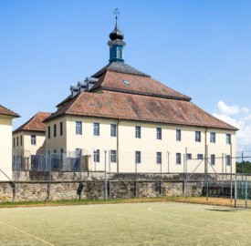 Bad Schönborn / Bad Mingolsheim - Schloss Kislau - Hauptbau - Von Nordwest - Blick vom ehemaligen Garten (heute Sportplatz) auf die Westfassade des Hauptbaus, links die Nordfassaden der beiden Flügel, ganz links im Anschnitt der Krankenbau (aufgenommen im Juni 2023, am Nachmittag)