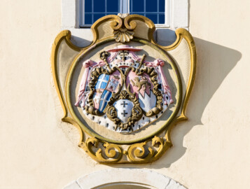 Bad Schönborn / Bad Mingolsheim - Schloss Kislau - Hauptbau - Von Norden - Blick auf das Prunkwappen an der Nordfassade des Mittelbaus (Landeswappen des Fürstbistums Speyer zur Regierungszeit des Fürstbischofs Kardinal Graf Damian Hugo von Schönborn - Linkes Wappen: links oben und rechts unten: Wappen des Bistums Speyer, links unten und rechts oben: Wappen der Fürstpropstei Weissenburg - Rechtes Wappen: persönliches Wappen von Damian Hugo von Schönborn - Mittleres unteres Wappen: zweifaches Deutsch-Ordenskreuz für die Ordensballeien Altenbiesen und Hessen) (aufgenommen im Juni 2023, am frühen Vormittag)