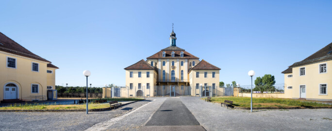 Bad Schönborn / Bad Mingolsheim - Schloss Kislau - Hauptbau - Von Norden - Blick vom Eingang des ehemaligen Ehrenhofs auf die Nordfassaden des Hauptbaus, des Ostflügels (links), des Westflügels (rechts) sowie auf den Küchenbau (ganz links) und den Krankenbau (ehemals Heiduckenbau / Lakaienspeisehaus, ganz rechts) (aufgenommen im Juni 2023, am Vormittag)