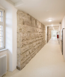 Bad Schönborn / Bad Mingolsheim - Schloss Kislau - Hauptbau - Von Innen - Erdgeschoss, westlicher Flur, außerhalb des ehemaligen Bergfrieds - Von Norden - Blick nach Süden in den westlichen Flur; rechts Zellen, links Quader des ehemaligen Bergfrieds (aufgenommen im April 2024, um die Mittagszeit)