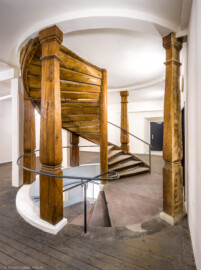 Bad Schönborn / Bad Mingolsheim - Schloss Kislau - Hauptbau - Von Innen - Treppenhaus, Zweites Obergeschoss - Von Nordost - Blick auf die hölzerne Treppe zum oberen Dachstuhl (oben) sowie auf die steinerne Treppe zum ersten Obergeschoss (unten); die Tür hinten führt in den unteren Dachstuhl (aufgenommen im April 2024, um die Mittagszeit)