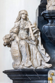Bruchsal - Peterskirche / St. Peter - Westlicher Chorraum - Doppelgrabdenkmal für Damian Hugo Philipp von Schönborn-Buchheim und für August von Limburg-Stirum -  Von Nordost - Blick auf die Plastik / Alabasterfigur "Der Glaube" mit einem Kreuz; die beiden allegorischen Figuren "Glaube" (links) und "Liebe" (rechts) halten Schilde, auf denen eine zusammengehörende lateinische Inschrift eingehauen ist; sie lautet auf Deutsch: "Dem Verstorbenen errichtete dieses Denkmal, des leiblichen Bruders fromme Seele mit Sehnsucht und Tränen geleitend der erhabene und vornehme Herr, Herr Rudolf Franz Erwin Graf von Schönborn, Buchheim und Wollschal etc., Ritter des Ordens vom Goldenen Vlies und engster Berater ihrer kaiserlichen Majestät etc."  (Mitte links am Grabdenkmal; Skulptur gefertigt von Ferdindanz Diez) (aufgenommen im Mai 2024, am frühen Nachmittag)